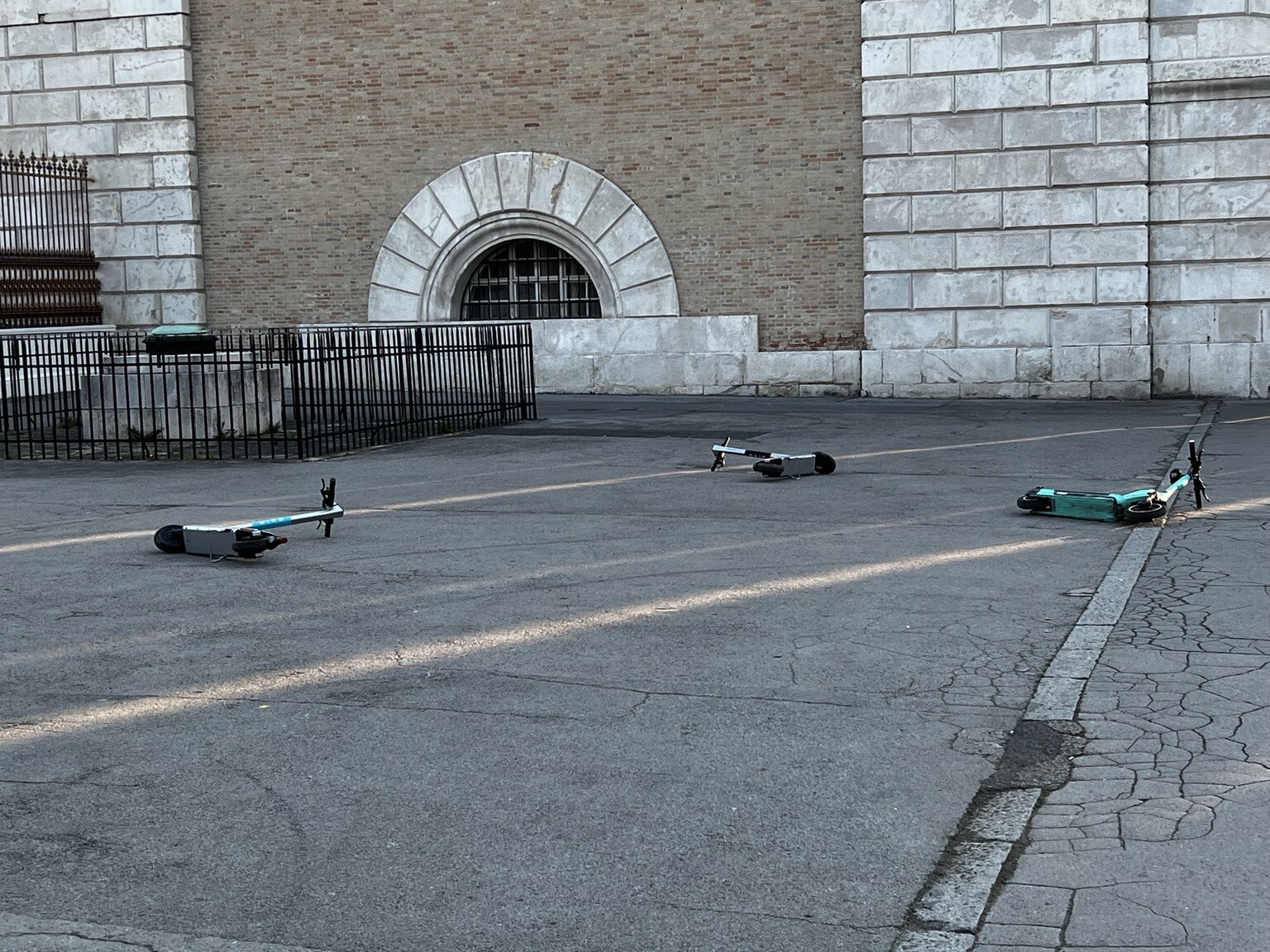 3 eScooter liegen etwas auseinander am Asphaltboden