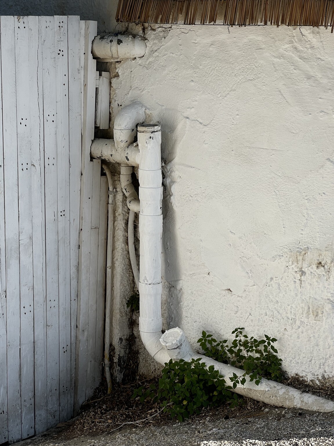 Unterschiedliche Rohre, die aus Mauer oder ab dieser entlang führen.