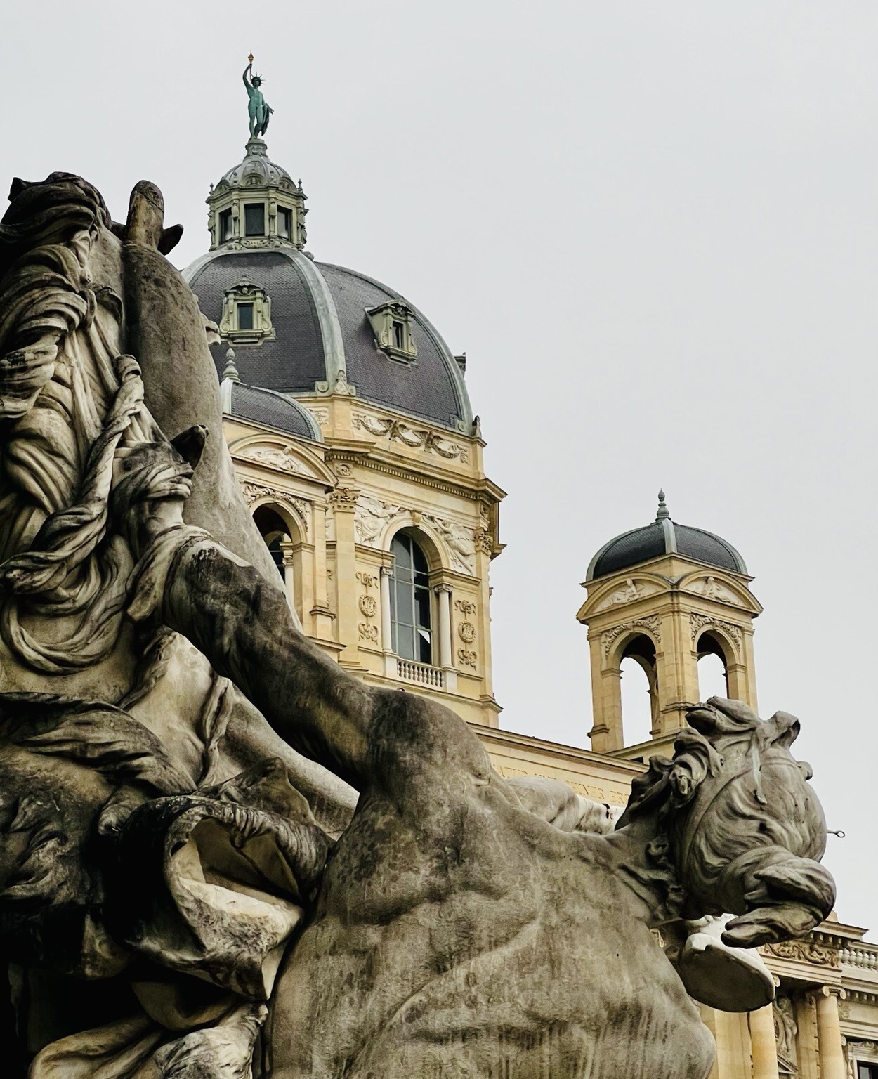 Statue eines nackten Menschen und Pferd von hinten. Dahinter Teile des Naturhistorischen Museums