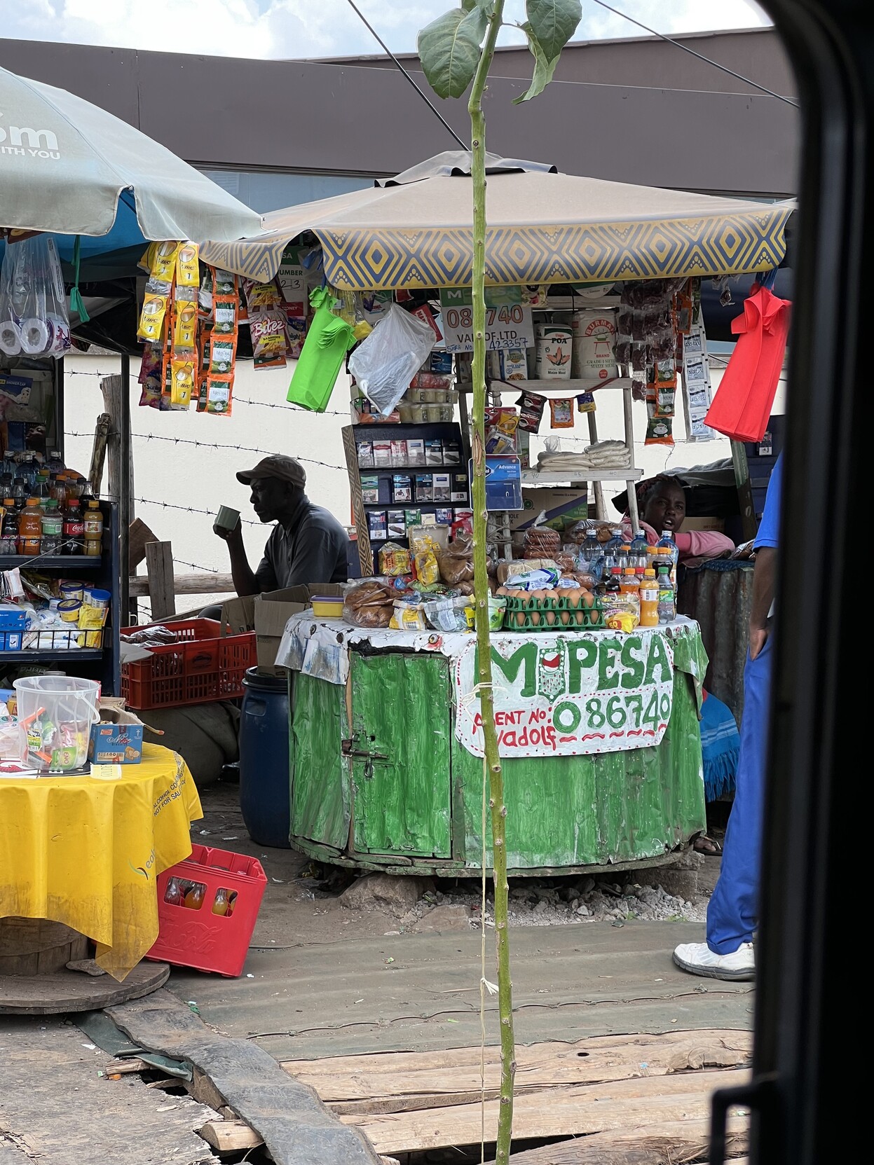 Kleiner Verkaufsstand mit Eiern, Getränken, Zigaretten etc und großer Aufschrift „MPESA“