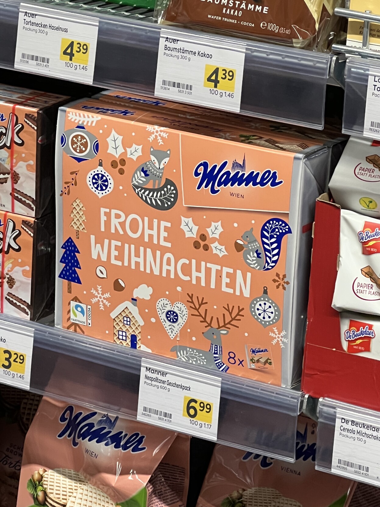 Große Schnittenpackung im Regal mit Aufschrift „Frohe Weihnachten“