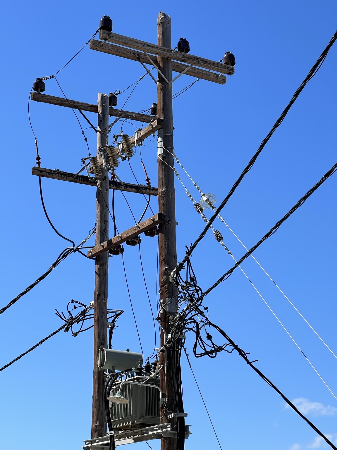 Strommast mit vielen Kabeln und anderen Aufbauten